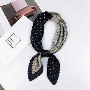 Détail d'un foulard carré plissé avec motifs floraux rétro et pois noirs mélangés
