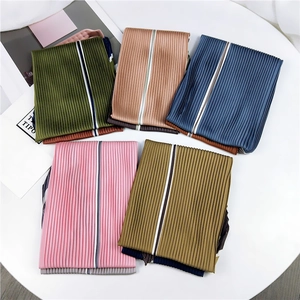 Détail de foulards en soie plissés aux couleurs variées avec rayures contrastées