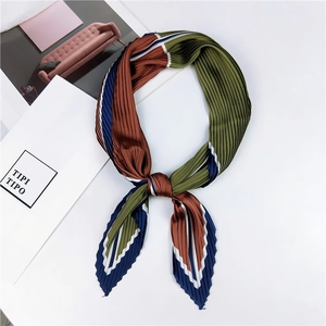 Détail d'un foulard en soie plissé aux motifs rayés multicolores sur fond blanc pur