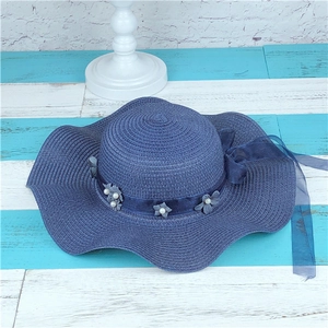Blue wave-edged straw sun hat with decorative flowers and pearls for beach vacation