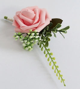Détail d'une boutonnière faite main en rose PE rose avec feuilles et baies blanches
