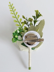 Détail du dos de la boutonnière en rose PE avec épingle de sûreté et clip en métal