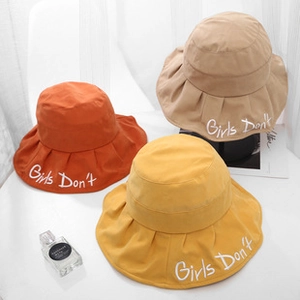 Detail van drie kleurrijke katoenen vissershoeden met Girls Don't borduursel erop