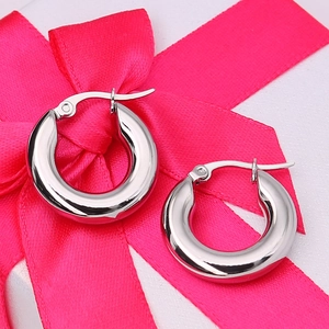 Minimalist silver chunky hoop earrings with high-polish finish in a gift packaging context