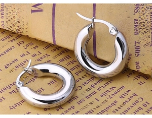 Macro shot of silver chunky hoop earrings showing the thick polished stainless steel finish