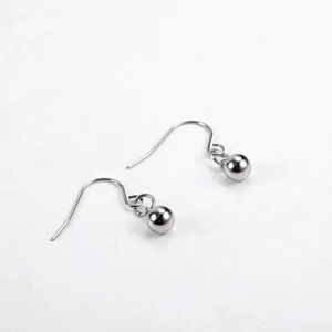 Macro detail of polished silver ball drop earrings with smooth metallic finish