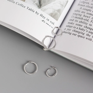 S925 sterling silver twisted hoop earrings in multiple sizes on a minimalist background