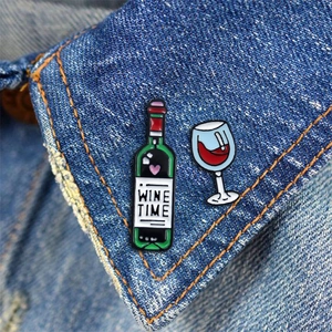 Emaille-Pins Weinzeit mit grüner Flasche und Rotweinglas auf einer Jeansjacke