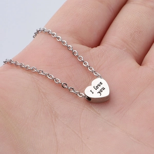 Silver stainless steel heart necklace engraved with I Love You held in hand