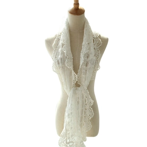 Elegant white lace scarf with floral embroidery and openwork design on a mannequin
