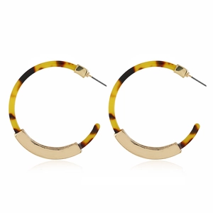 Detail of retro geometric wood earrings with gold metal and tortoiseshell resin texture