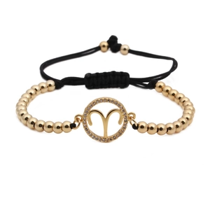 Macro shot of Aries zodiac charm with cubic zirconia on a black woven beaded bracelet