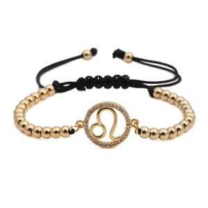 Detailed shot of gold Leo zodiac charm with micro-set zircons on black braided cord