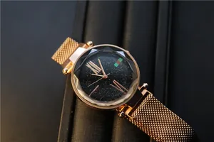 Close-up of starry sky dial with faceted glass and rose gold mesh band watch