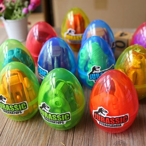 Miniature colorful dinosaur toys inside transparent Jurassic eggs on a wooden surface