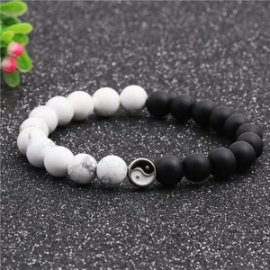 Yin Yang distance bracelets with matte black and white turquoise beads on dark background
