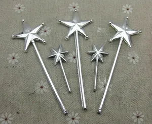 Detailed view of five silver-plated star fairy wands on rustic floral fabric