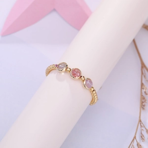 Eleganter Perlenring mit rosa Erdbeerkristall und violetten Steinen auf goldenem Band