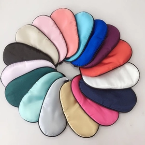 Overhead view showing sixteen colorful satin sleep masks arranged in a circular flower pattern