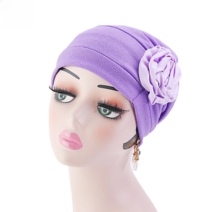 Détail macro du foulard plissé violet avec grande applique florale en satin sur fond blanc