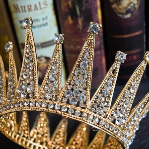Close-up of golden vintage bridal crown with shimmering white rhinestones on antique books