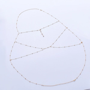 Detail view of multi-layer gold body chain with beaded fringe and lobster clasp closure