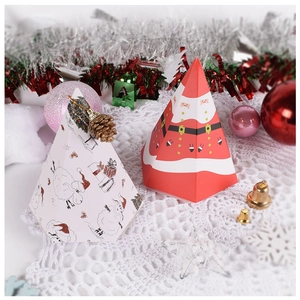 Christmas pyramid gift boxes with Santa and sheep designs on white crochet tablecloth