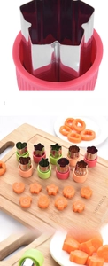Detail showing various stainless steel cookie cutters on a wooden board with shaped carrots