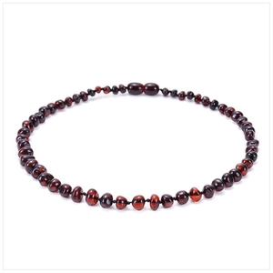 Detailed view of polished dark red Baltic amber beads with translucent texture