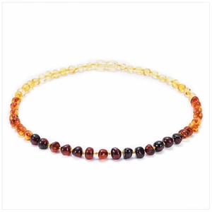 Macro detail of multi-colored Baltic amber bead necklace for babies in oval layout