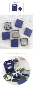 Navy blue jewelry gift box and matching carrier bag with elegant white ribbon detail