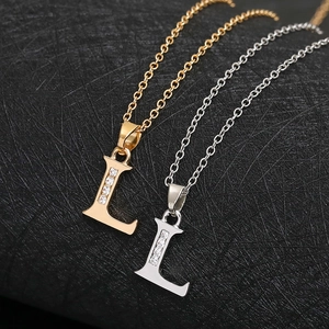 Close-up of letter L pendant necklaces in gold and silver finish with sparkling crystals