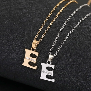 Sparkling copper necklace featuring letter E pendant with cubic zirconia inlay in gold and silver