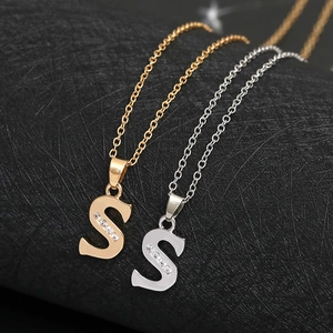 Detailed view of gold and silver letter S necklaces with sparkling vertical zircon accents