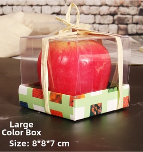 Detalle de una vela decorativa de manzana roja en una caja de regalo de PVC transparente