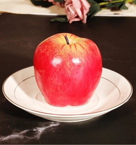 Primer plano de una vela realista de manzana roja con textura brillante en un plato blanco