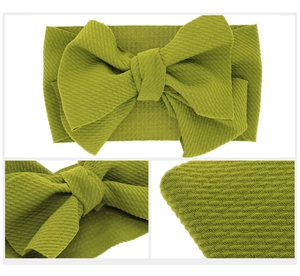 Detail of olive green waffle fabric baby headband featuring a large textured bow design