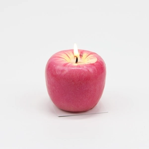 Primer plano detallado de una vela realista con forma de manzana roja sobre fondo blanco