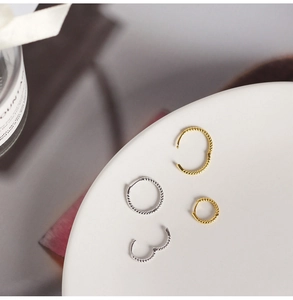 Detailed view of S925 sterling silver twisted hoop earrings in gold and silver finishes