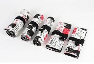 Detail of printed canvas pencil wraps with cartoon cat patterns in various rolled states