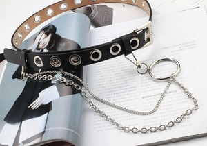 Close-up of punk style black leather belt with silver eyelets and metal chain detail