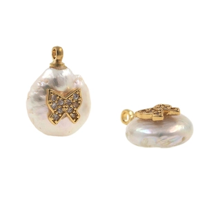 Macro view of baroque pearl button pendant with gold butterfly and micro-set crystals