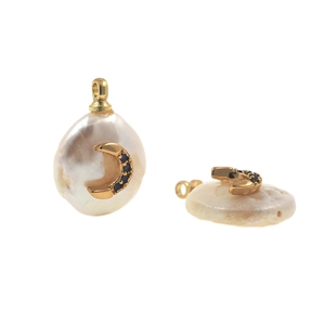 Close-up of baroque pearl charms with gold crescent moon inlay and blue gemstones