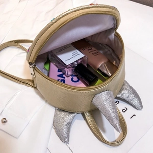 Detail view of a cute children's mini sequin unicorn backpack in gold with glitter horns.