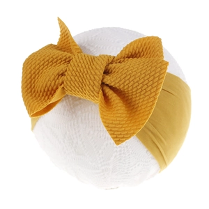 Detail of ginger yellow waffle knit nylon headband for infants with large bow tie