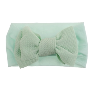 Detail of mint green waffle knit fabric texture on soft elastic nylon baby headband