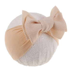 Detail of soft waffle knit baby headband with a large pink bow on a display prop