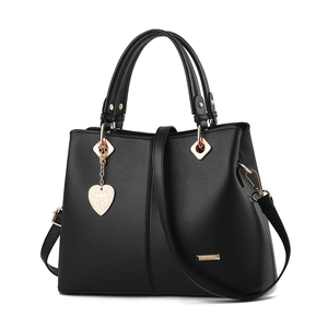 Women's black tote bag with gold hardware, heart charm, and detachable strap on white background