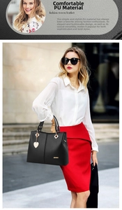 Detail of black PU leather handbag featuring a golden heart pendant and metallic logo