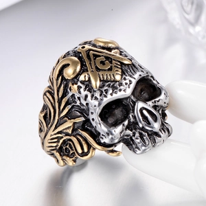 Macro detail of gothic skull ring with golden Freemason logo on white hand model